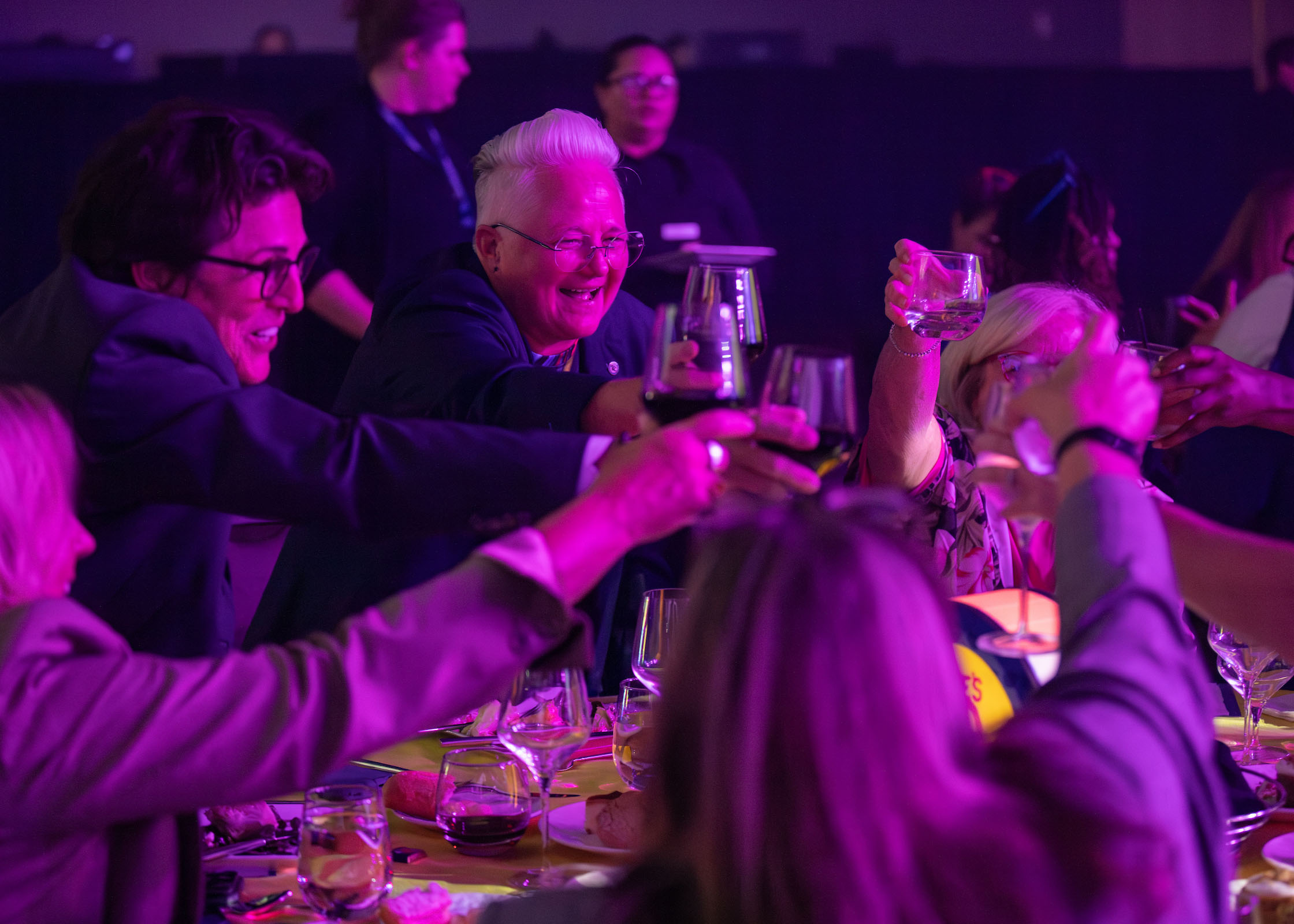 TCC Senior VP & CAO Dr. Angela Sivadon raises her wine glass toast with the others at her table.